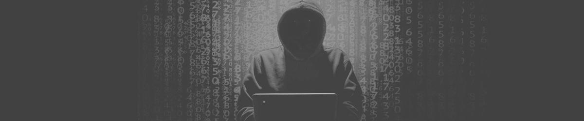 Person mit Hoodie am Laptop vor Hintergrund mit vielen Zahlen und Buchstaben